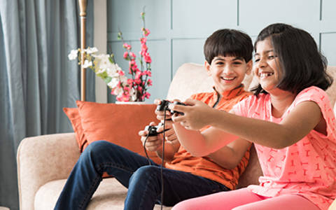 Asad and Inaya laughing playing computer games