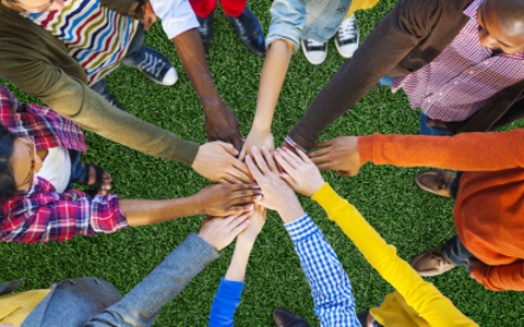 Groups of people wearing colourful outfits with outreached hands