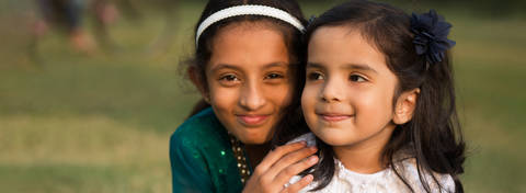 Two foster girls smiling in a park